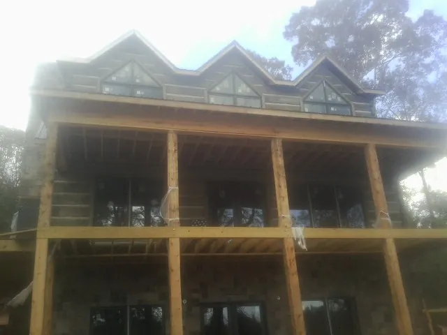 Dormers and porch framing on a large log home under construction in Lawtey