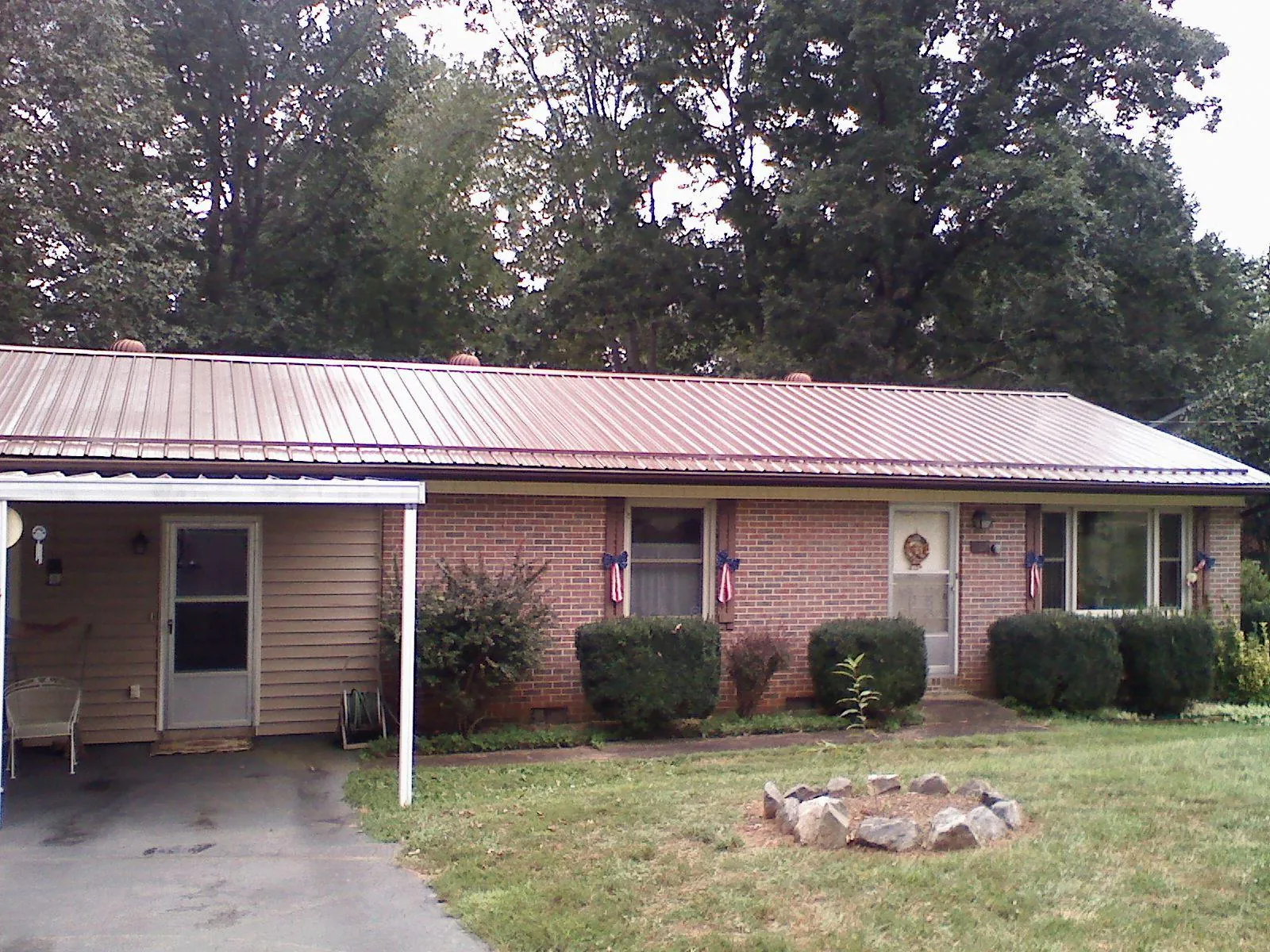 Bronze metal roof and carport on a brick ranch home — Roof Repair work by our crew in Lawtey